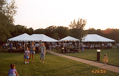 Scene of the crowd and tents set up for dining and the silent auction.